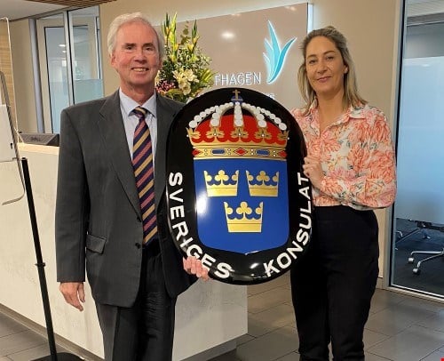 Honorary Consul Ashley Harris handing over the coat of arms to our new Honorary Consul Cara Hawkins